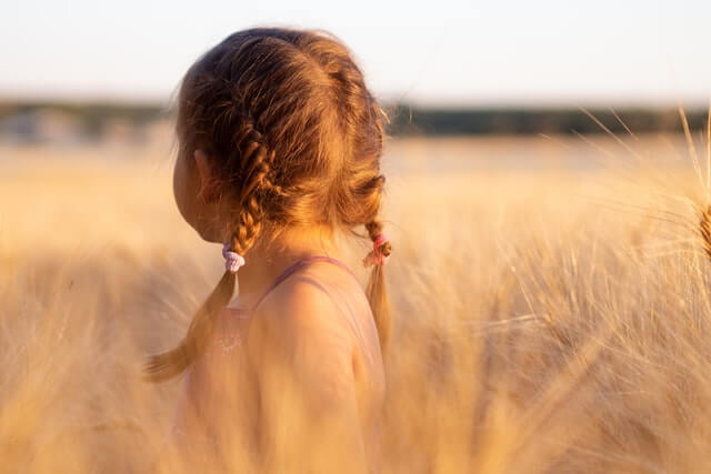 Fröhliches junges Mädchen im Getreidefeld, Sommerzeit